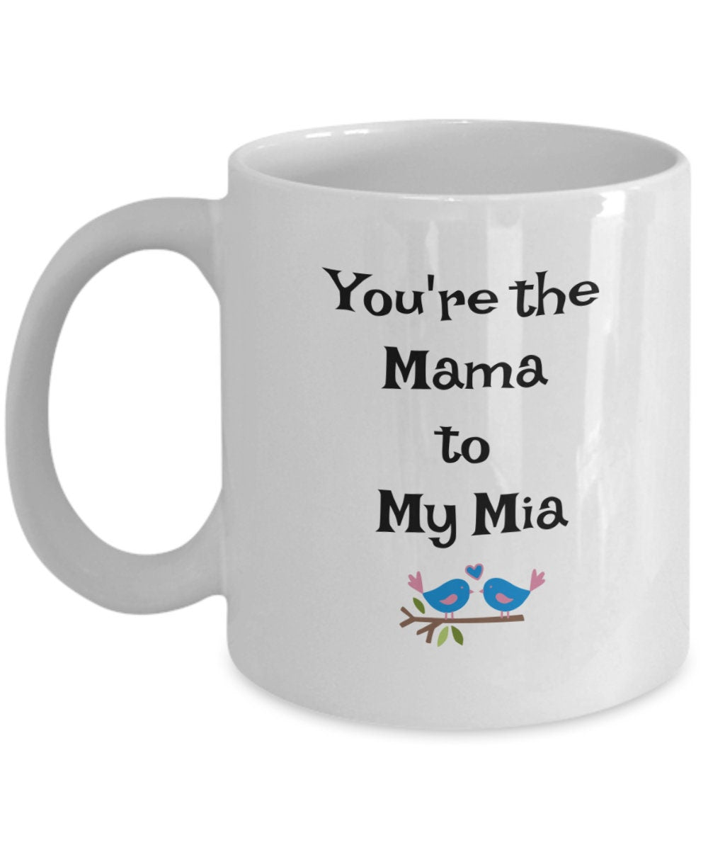 White mug with the text "You're the Mama to My Mia" and two blue birds on a branch, novelty gift for moms or couples.